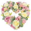 This photograph captures a beautifully crafted, heart-shaped funeral wreath brimming with soft pastel flowers and framed by subtle greenery, shown against a neutral white backdrop. The heart is completely filled with blooms, its curves smooth and unbroken, creating an impression of fullness and quiet luxury. Cream and pale yellow roses take pride of place, their elegantly layered petals drawing the eye toward the centre of each bloom, where the colour is deepest and most serene. Between them, clusters of pale pink carnations spread out in ruffled layers, giving the tribute a comforting, cushiony texture that feels soothing to imagine touching. Richer magenta-pink lisianthus flowers appear at intervals, their more open, cup-like petals and gentle swirls providing tonal depth, like deeper notes in a piece of music played softly at a service in or around Wennington. Threaded throughout, sprigs of silvery-green eucalyptus add a cool, misty tone and a fresh, leafy scent, their rounded leaves echoing the tranquil, rural edges around the village. Tiny yellow-green buds dot the design, offering small flashes of spring-like brightness among the pastels. The wreath's overall expression is one of tender remembrance and heartfelt sympathy, suitable for placing beside a coffin, on a stand at a chapel, or delivered as a condolence tribute to a local family. It feels like a quiet promise of enduring love, created by a caring florist who understands how important flowers can be when saying a final goodbye.